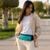 Sac banane femme turquoise avec fermeture éclair et logo visible porté en ceinture