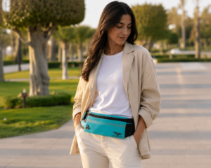 Sac banane femme turquoise avec fermeture éclair et logo visible porté en ceinture